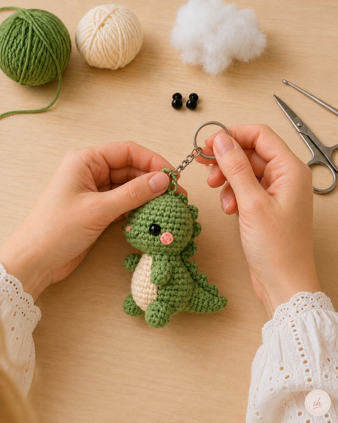 Schlüsselring wird in die Schlaufe am Kopf des Dino Amigurumi Schlüsselanhängers eingehängt
