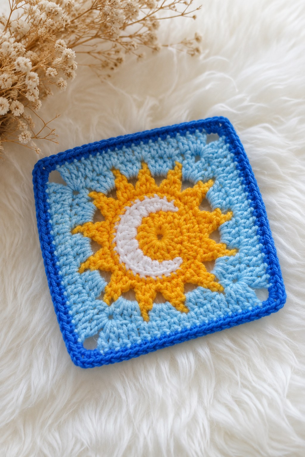 Blaues Granny Square Muster mit gehäkeltem Sonnen- und Mondmotiv