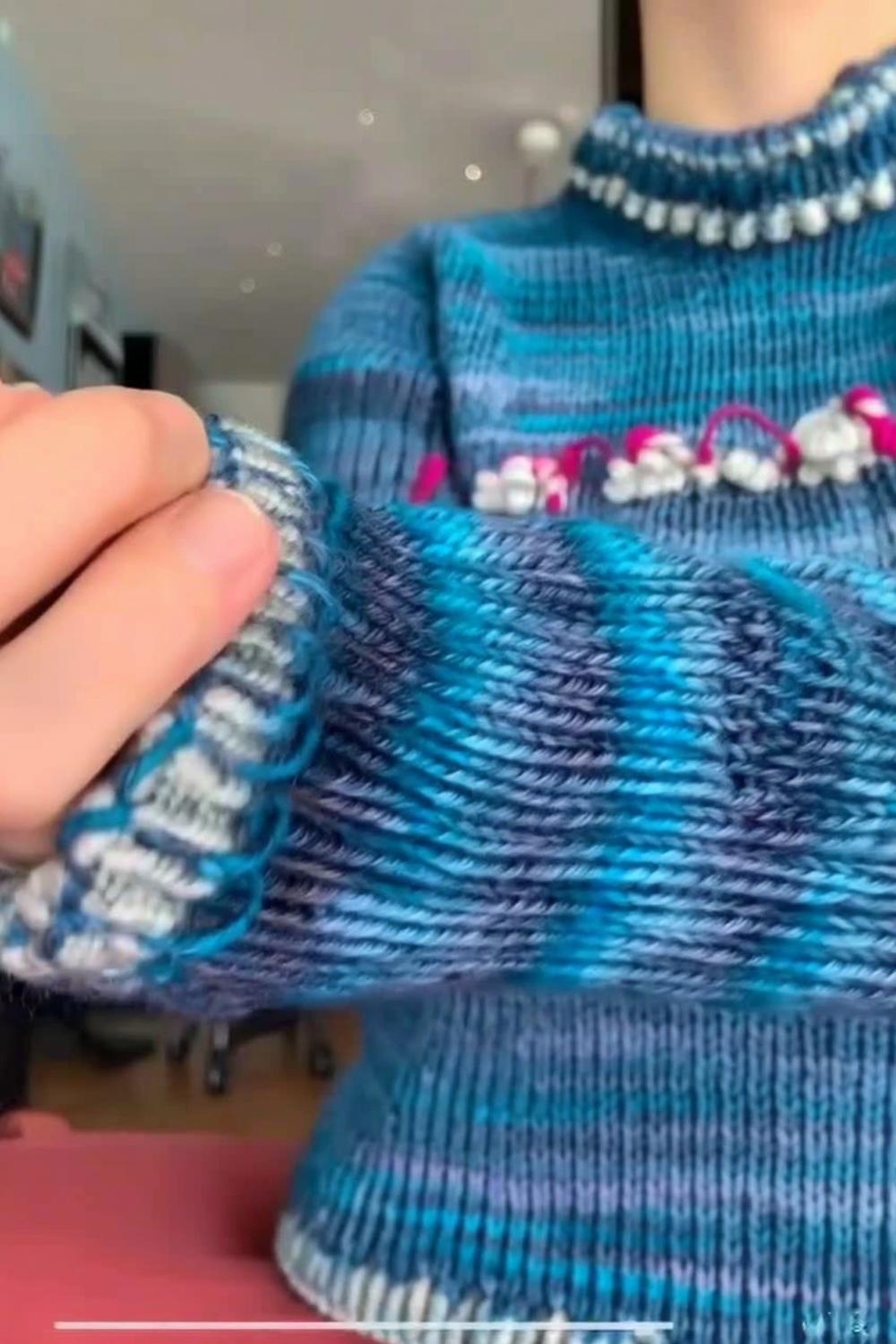 Blauer Pullover mit Perlenverzierung
