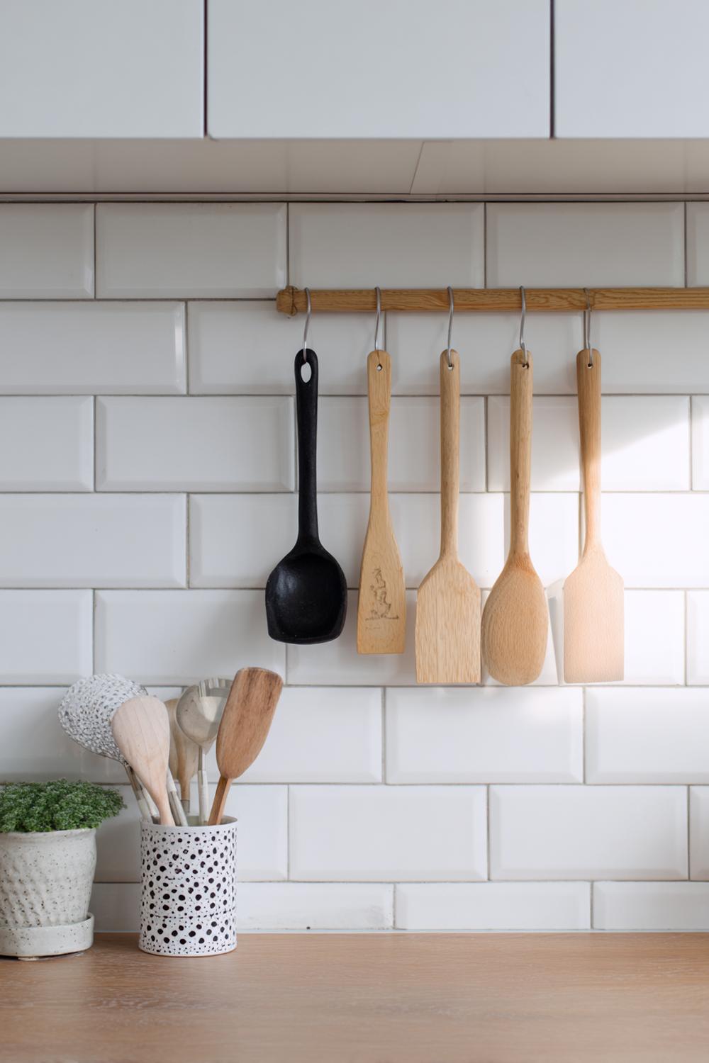 17. Küche Deko Ideen modern: Küchenrückwand-Reling mit hängenden Holzutensilien