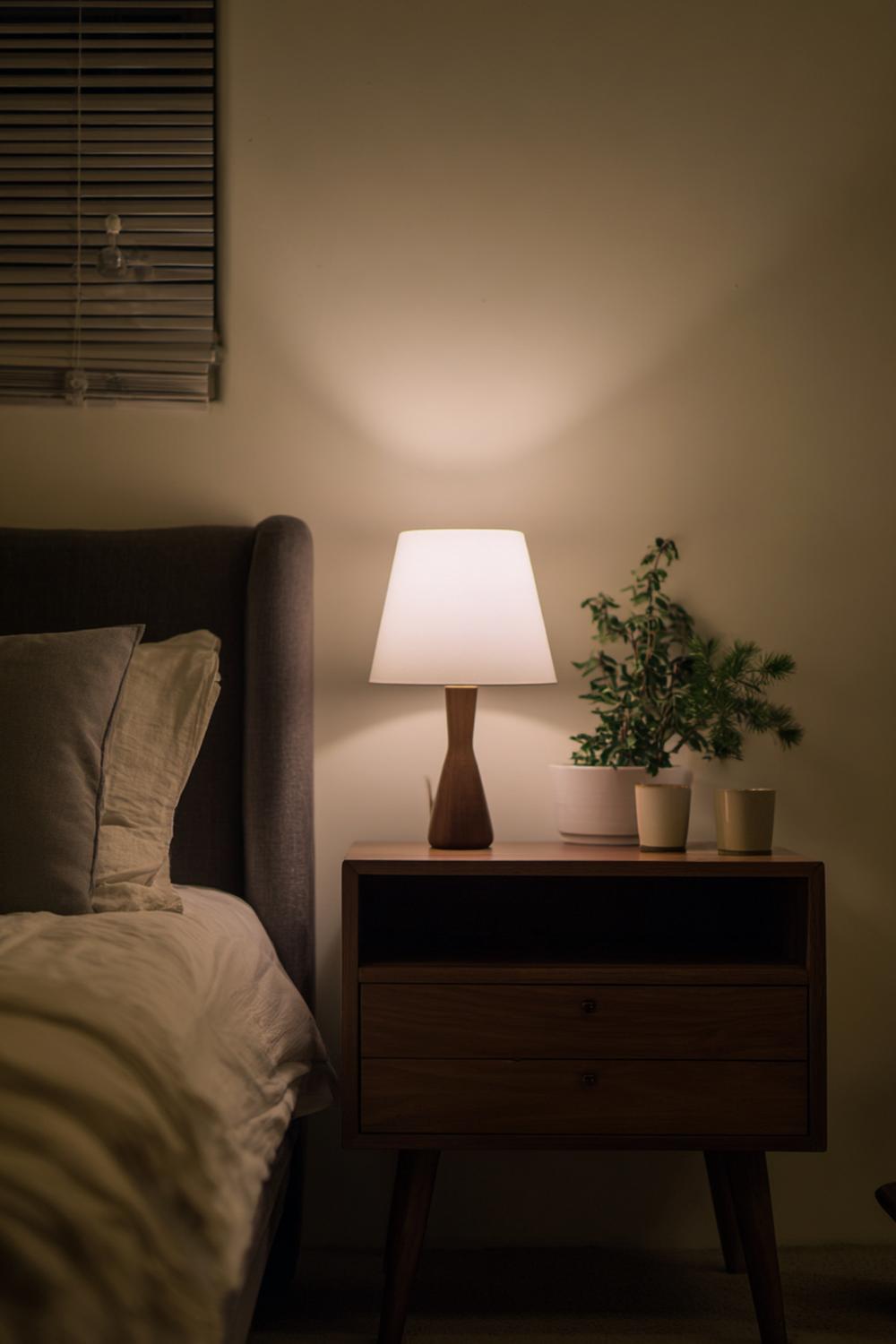 8. Nachttisch-Dekoration mit Wandlampe, leerer Fläche und einem Statement-Buch