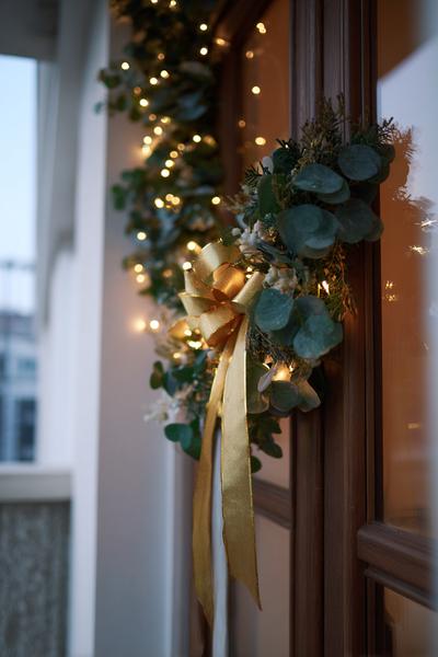 16. Türrahmen-Dekoration als ribbon bow garland mit Eukalyptus und warmen Lichtern