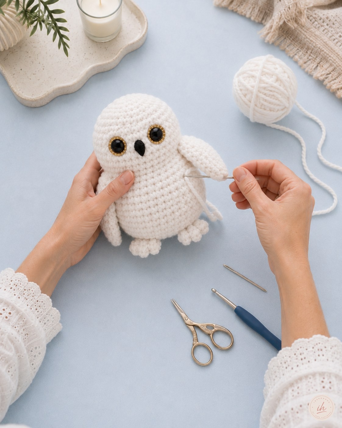 Flügel werden an der fast fertigen Schneeeule Amigurumi festgenäht