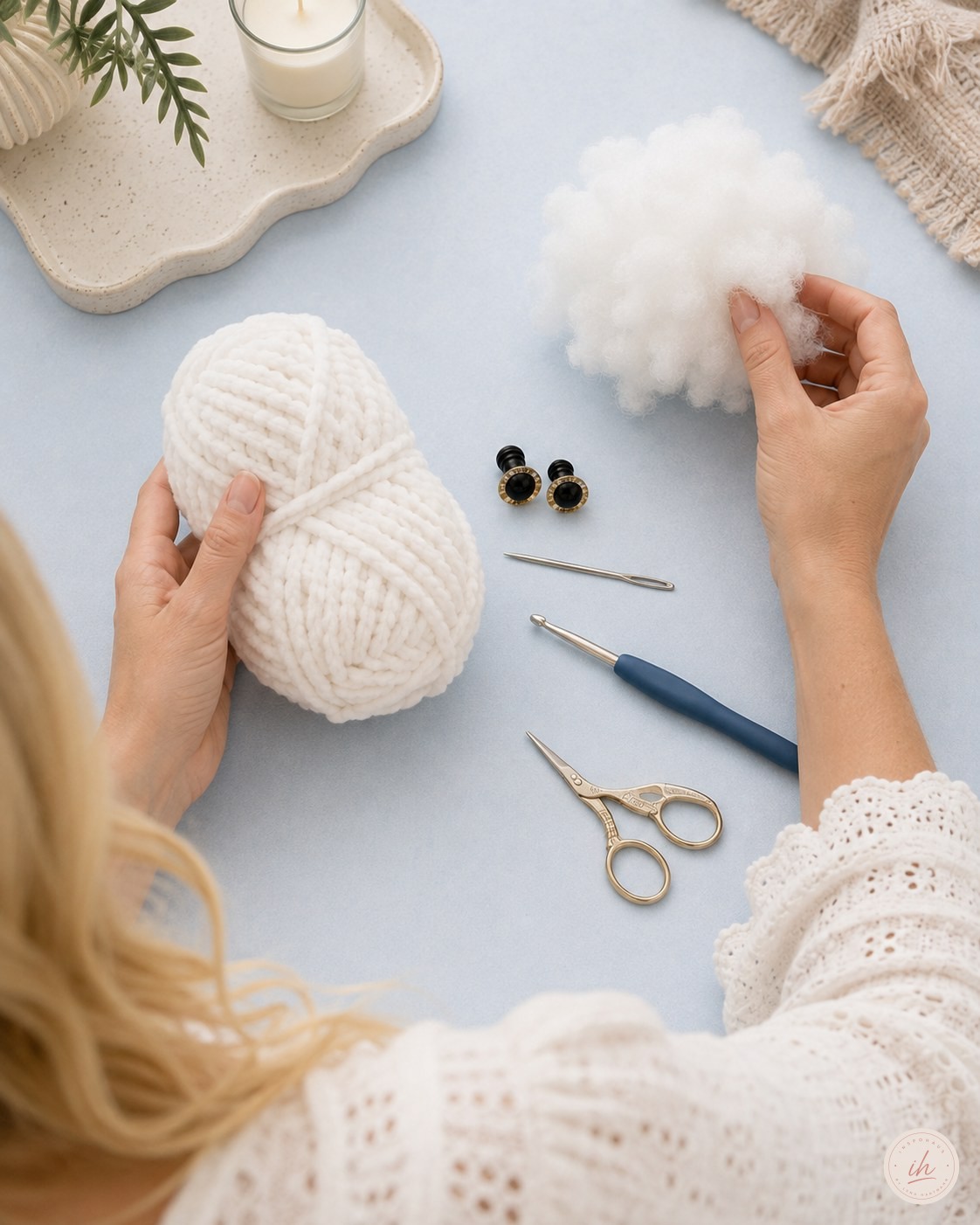 Vorbereitung der Materialien fürs Schneeeule Amigurumi häkeln mit Wolle und Füllwatte in der Hand