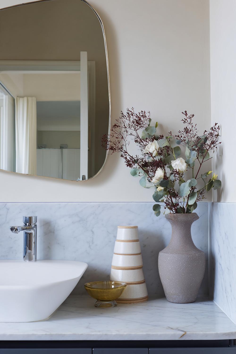 10. Spiegeldeko Bad Ideen mit asymmetrischem Spiegel und gestapelten Bücherattrappen