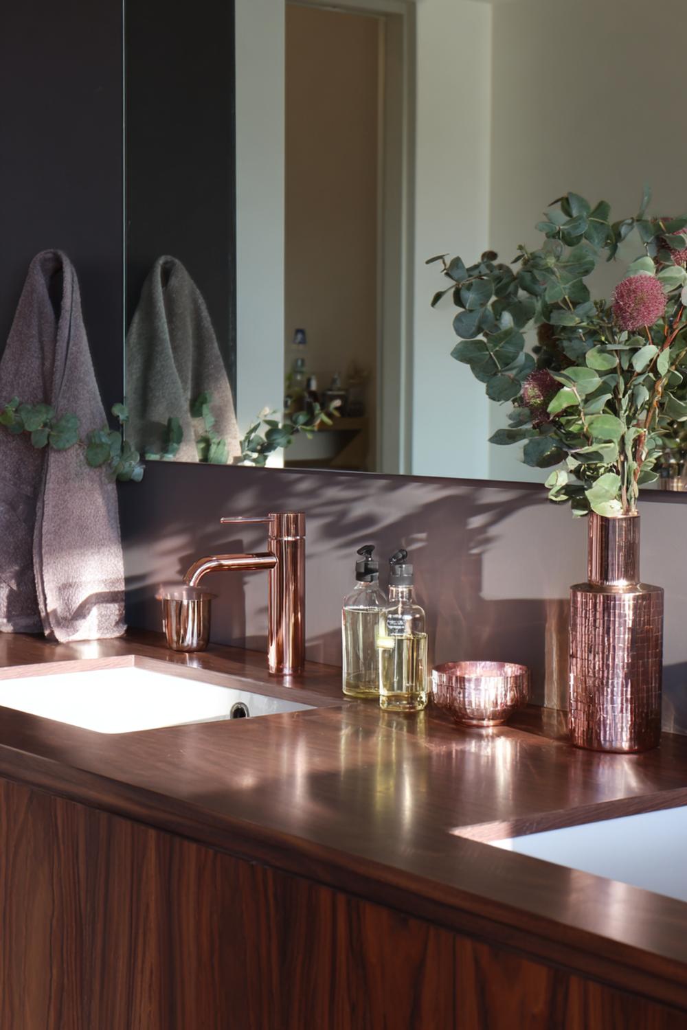 32. Spiegeldeko Bad Ideen mit dunklem Holz und kupferfarbenen Details